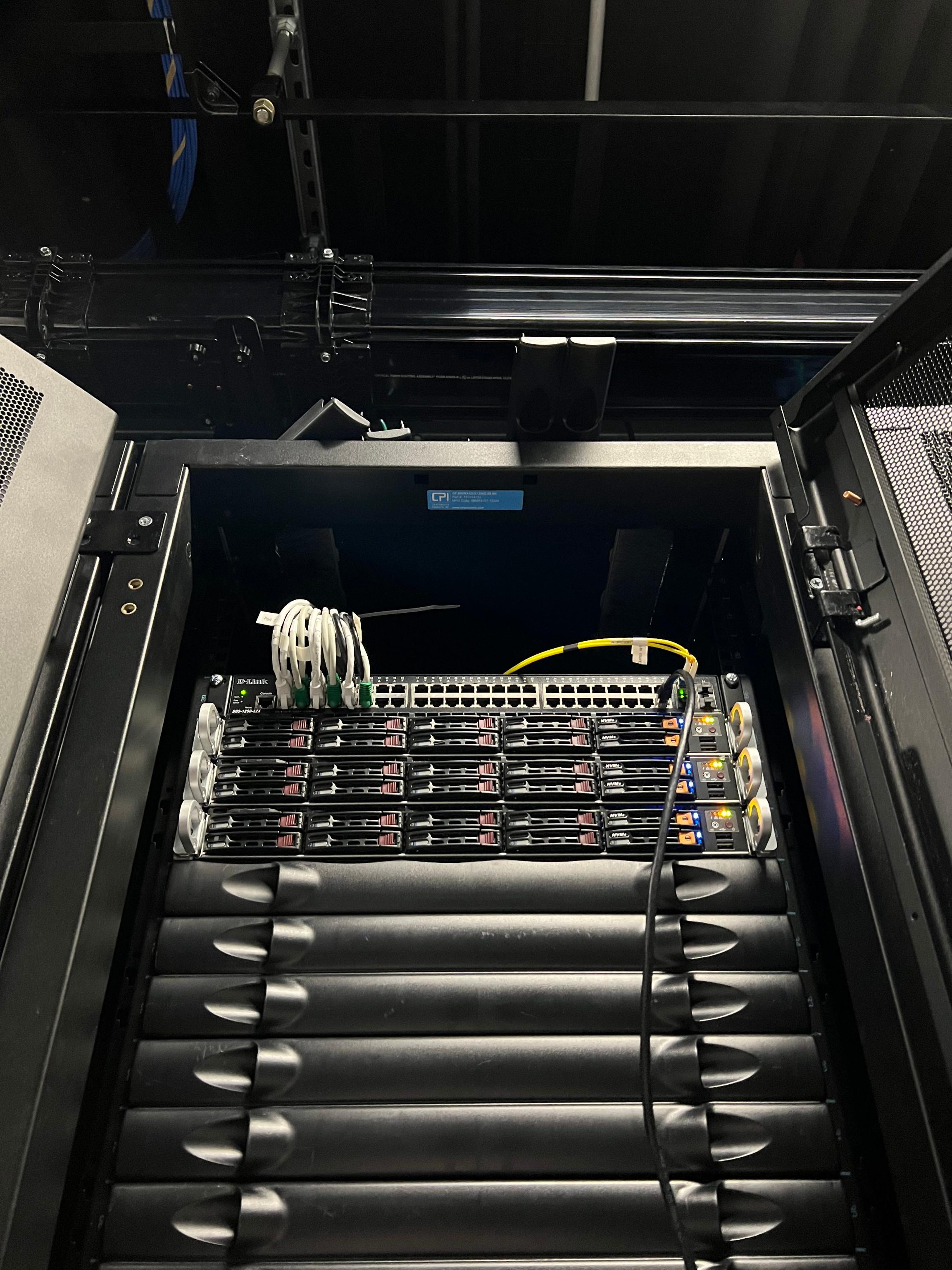 Photo of the top of a 42U cabinet with three servers and a switch